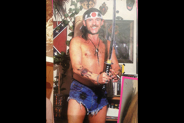 2. Lemmy Wears Short-Shorts, Holding A Katana, While Smoking A Cigarette